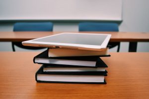silver ipad on books